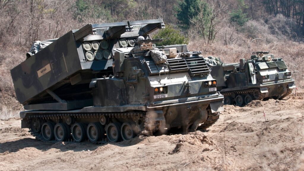 M270 Multiple Launch Rocket System launcher vehicles on a dirt range