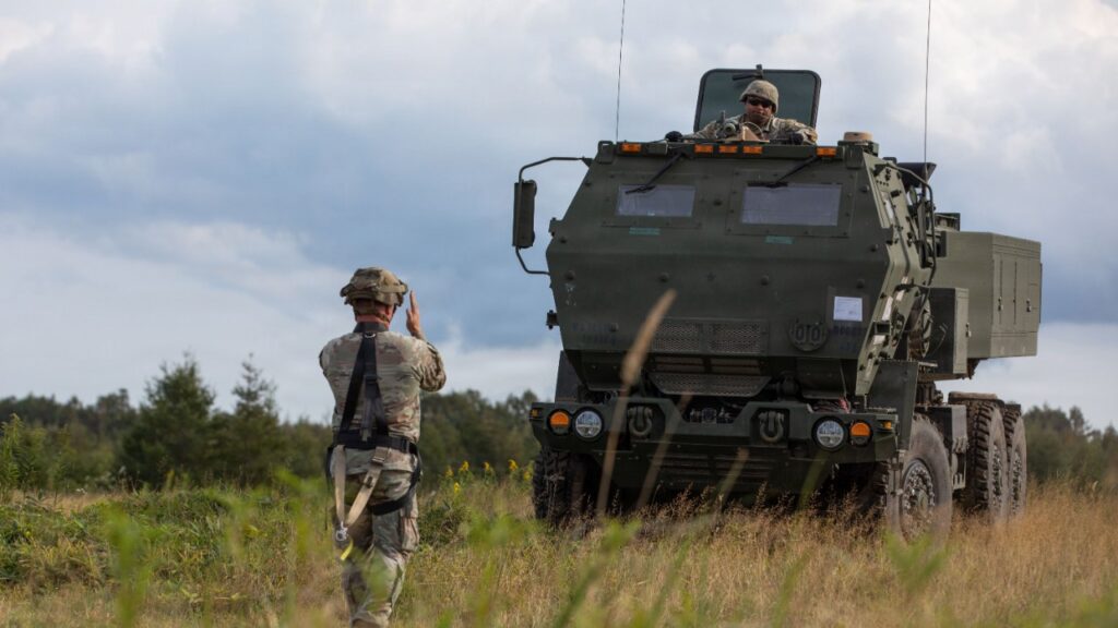 M142 HIMARS rocket launcher truck in a grassy field