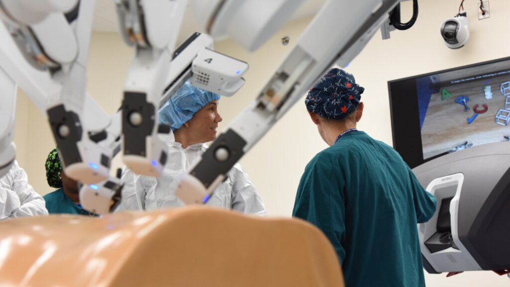 Robotic surgical arms in an operating room with medical staff