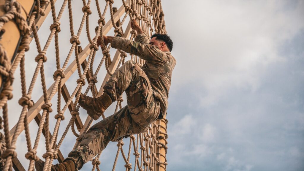 Soldier climbing a cargo net on an obstacle course