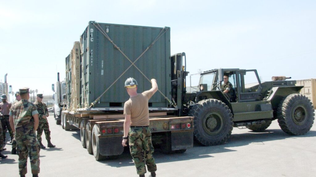 Sailors moving a TRICON container with a forklift