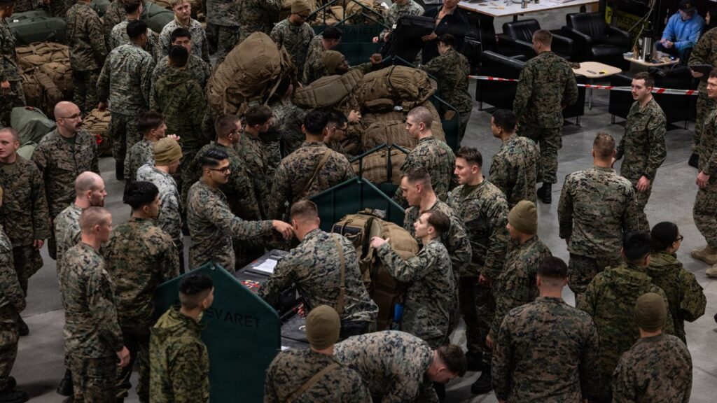U.S. Marines in cold-weather gear gathering after arriving in Norway