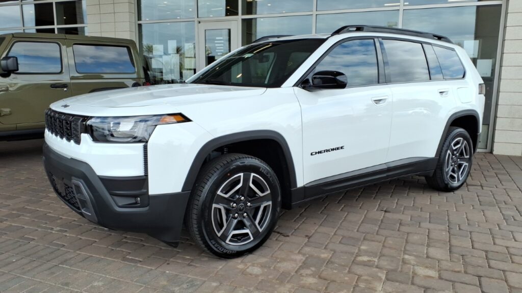 White 2026 Jeep Cherokee Laredo SUV parked outside a building