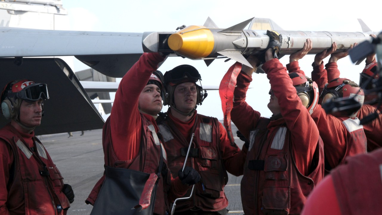 Aviation ordnancemen from Strike Fighter Squadron (VFA) 41 handle an AIM-9X Sidewinder, September 2009.