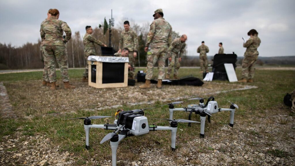 Army cavalry soldiers set up drone and electronic warfare equipment in a field