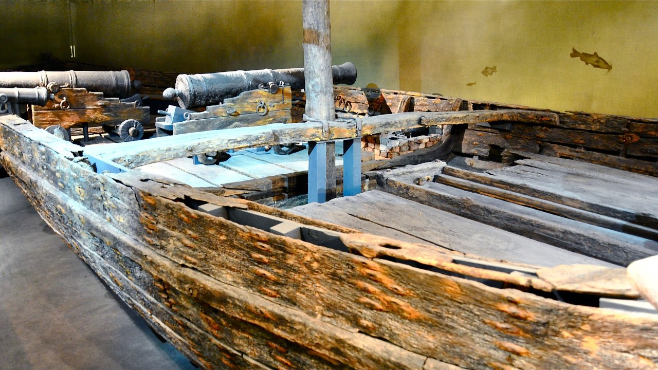 The wooden hull of the gunboat Philadelphia with cannon in a museum gallery